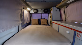 Cama doble preparada en una camper van